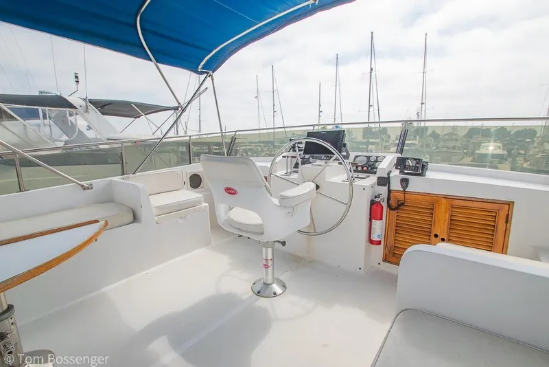 Slide: The Image of Helm of 1986 Ponderosa 47 yacht with blue canopy and marina view. - 45