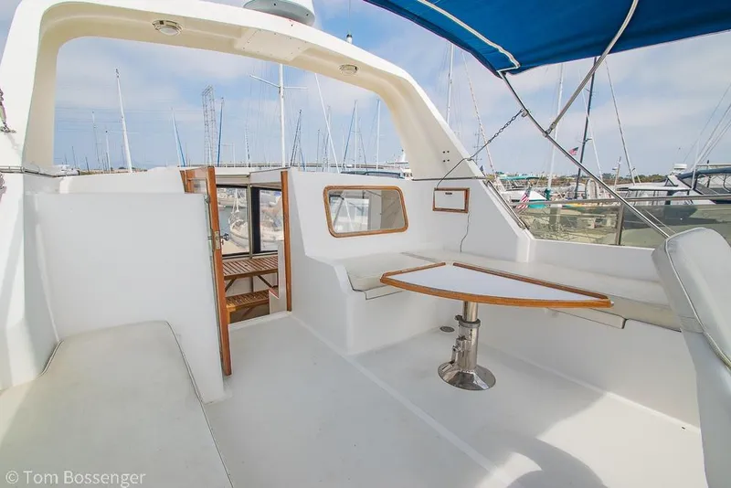 Slide: The Image of 1986 Ponderosa 47 yacht interior with seating and table, docked at marina. - 46