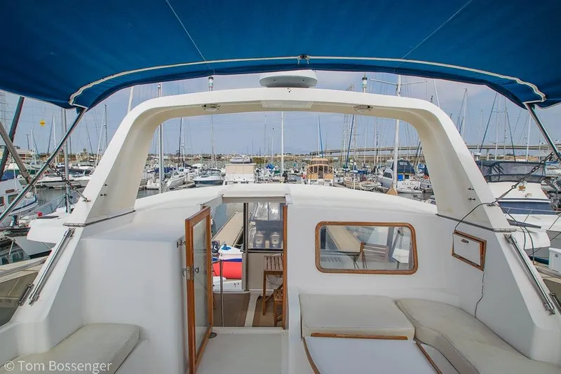 Slide: The Image of 1986 Ponderosa 47 yacht interior with blue canopy, docked in a marina. - 55