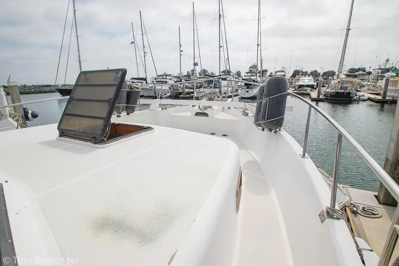 Slide: The Image of 1986 Ponderosa 47 yacht docked at marina, featuring open deck and hatch. - 62