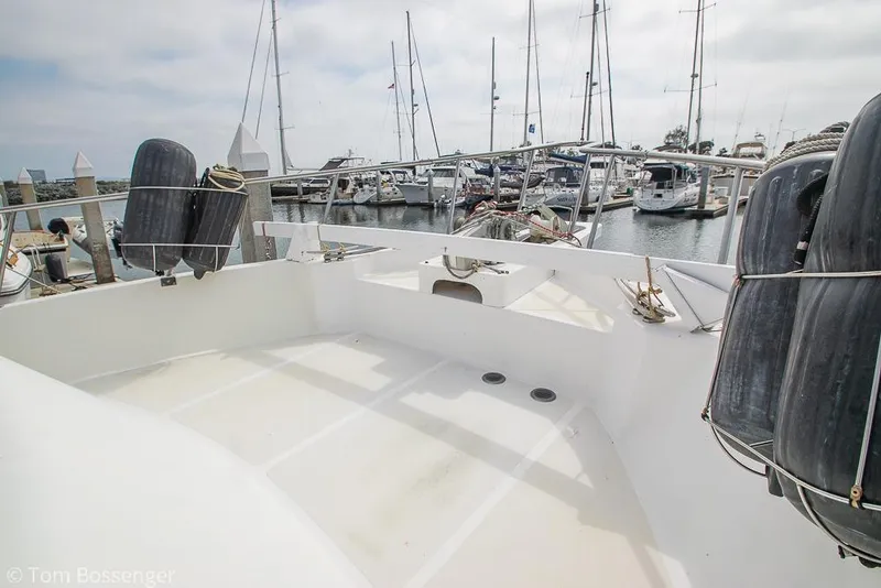 Slide: The Image of 1986 Ponderosa 47 yacht deck with marina view, featuring moored boats and clear skies. - 63