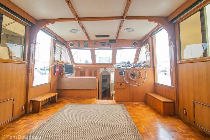 Slide: The Image of 1986 Ponderosa 47 yacht interior with wooden paneling and steering wheel. - 7