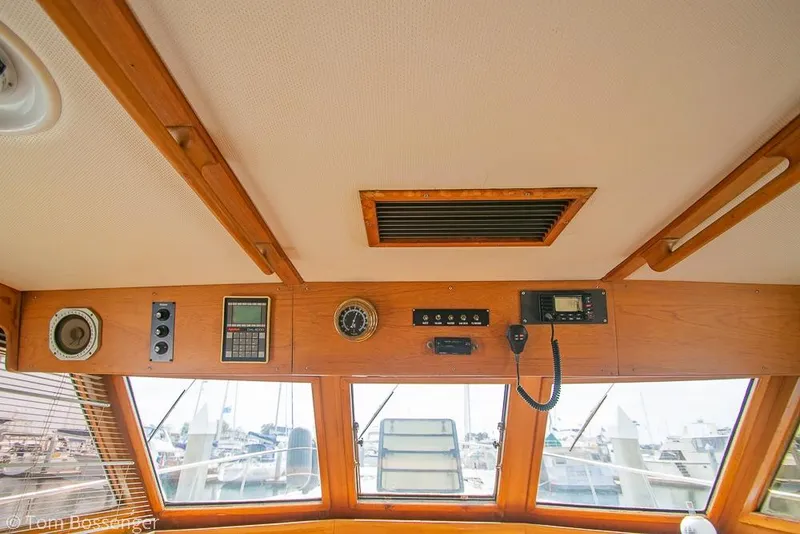Slide: The Image of Interior view of 1986 Ponderosa 47 boat cockpit with navigation instruments and wooden paneling. - 74