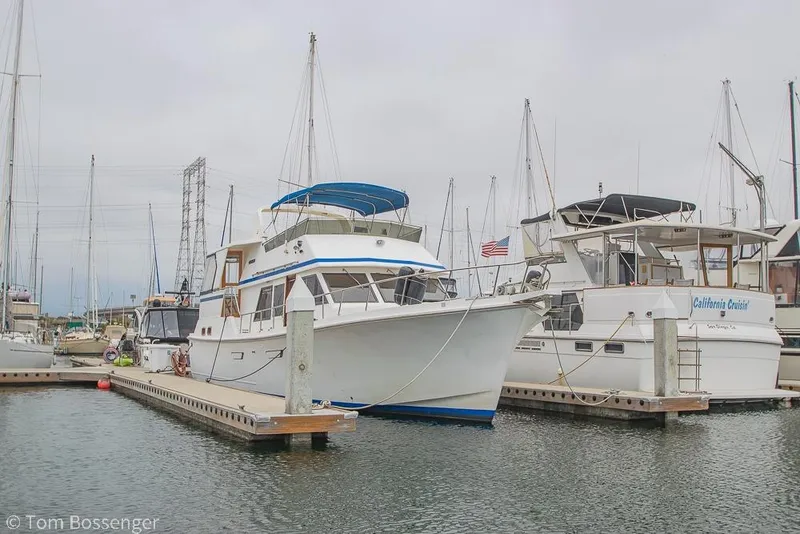 Slide: The Image of 1986 Ponderosa 47 yacht docked at marina, surrounded by other boats. - 84