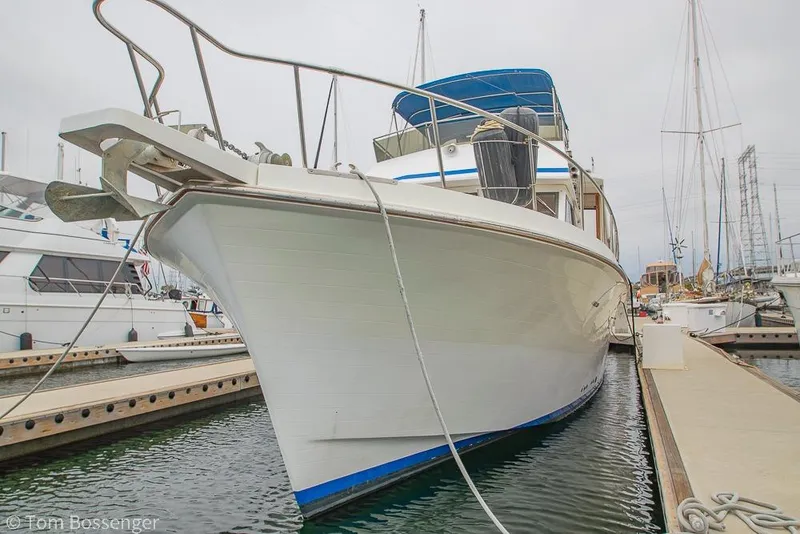 Slide: The Image of 1986 Ponderosa 47 yacht docked at marina, featuring sleek design and blue accents. - 90