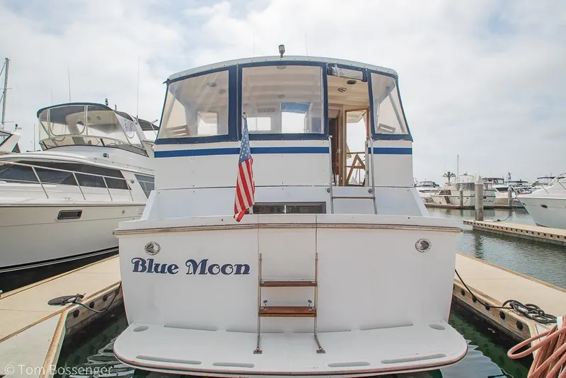 Slide: The Image of 1986 Ponderosa 47 yacht "Blue Moon" docked at marina with American flag. - 93