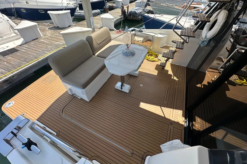 Slide: The Image of 2017 Bavaria Virtess 420 Fly yacht deck with seating and table at marina. - 7