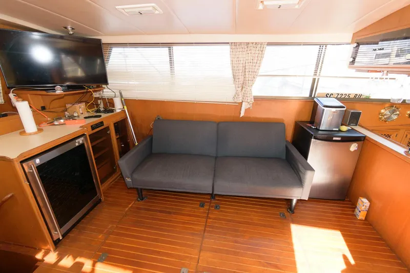 Slide: The Image of Interior of 1988 Symbol 55 Cockpit Motor Yacht with sofa, TV, and kitchenette. - 13