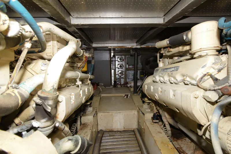 Slide: The Image of Engine room of 1988 Symbol 55 Cockpit Motor Yacht, showcasing dual engines and mechanical components. - 25