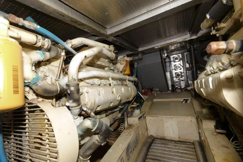 Slide: The Image of Engine room of 1988 Symbol 55 Cockpit Motor Yacht, showcasing mechanical components and piping. - 27