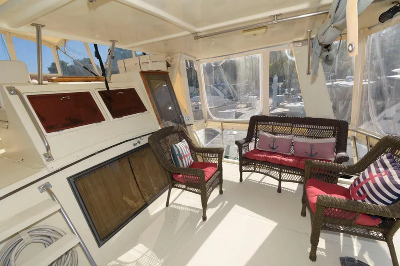 Slide: The Image of 1988 Symbol 55 Cockpit Motor Yacht interior with wicker seating and nautical-themed cushions. - 4