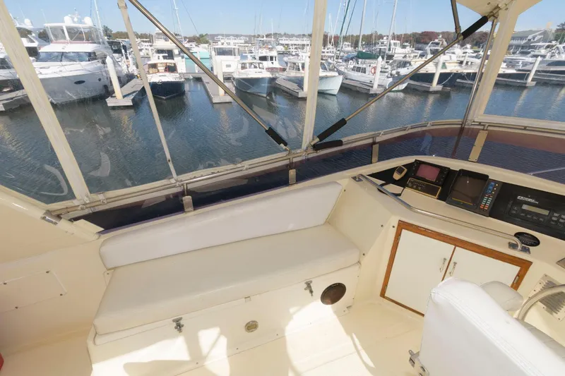 Slide: The Image of 1988 Symbol 55 Cockpit Motor Yacht interior with marina view, featuring navigation equipment and seating. - 7