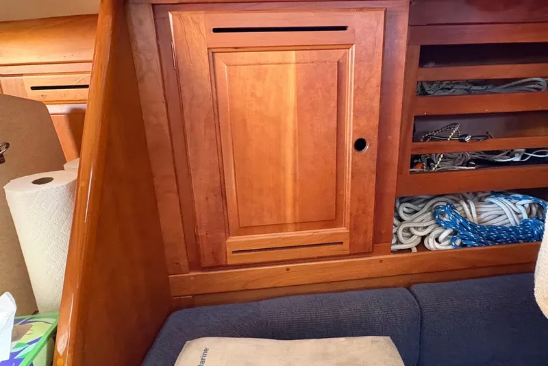 Slide: The Image of Wooden interior of a 2005 Tartan 4100 sailboat with storage compartments and ropes. - 10