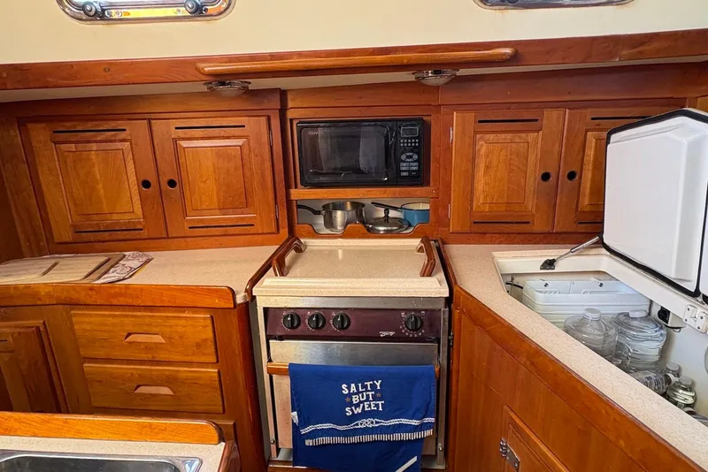 Slide: The Image of Cozy Tartan 4100 yacht kitchen with wooden cabinets, stove, and microwave, 2005 model. - 12