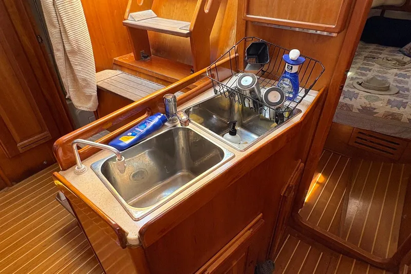 Slide: The Image of Galley kitchen in 2005 Tartan 4100 sailboat with sink and wooden cabinetry. - 14