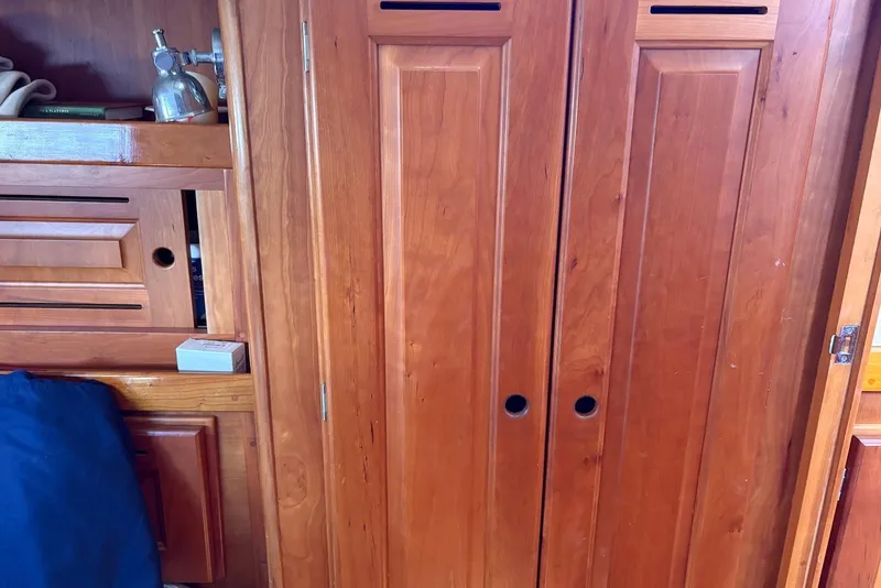 Slide: The Image of Wooden interior of a 2005 Tartan 4100 sailboat, featuring cabinets and storage. - 17