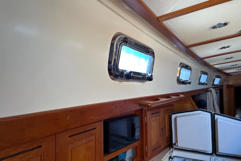 Slide: The Image of Interior of a 2005 Tartan 4100 yacht with portholes and wooden cabinetry. - 19