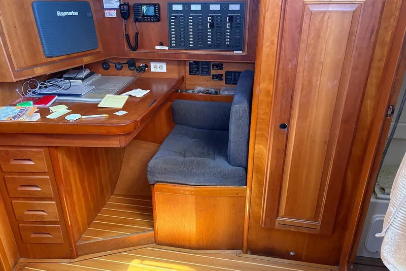 Slide: The Image of Navigation station in a 2005 Tartan 4100 sailboat with wooden cabinetry and control panels. - 20