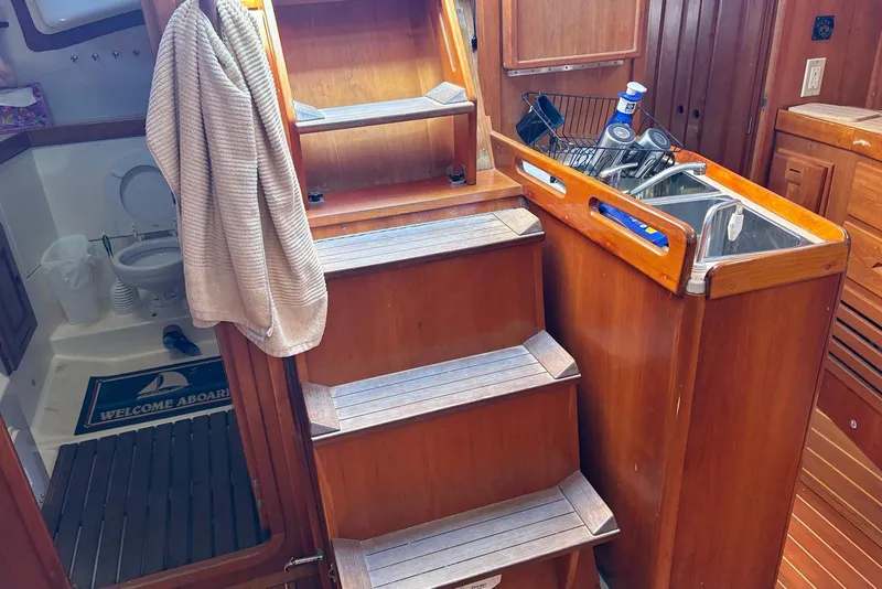 Slide: The Image of Interior of 2005 Tartan 4100 sailboat with wooden stairs, sink, and bathroom. - 21