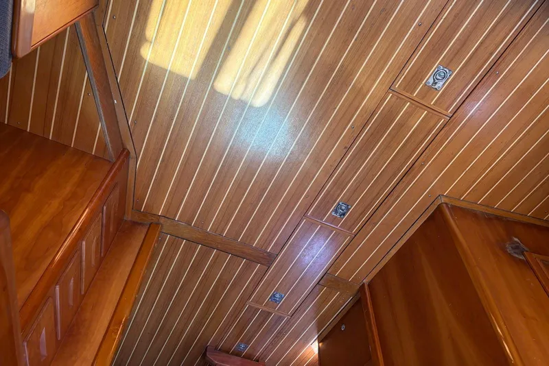 Slide: The Image of Wooden interior of a 2005 Tartan 4100 sailboat, featuring polished paneling and storage compartments. - 22