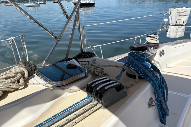 Slide: The Image of Deck of 2005 Tartan 4100 sailboat with ropes and winch, docked on calm water. - 23