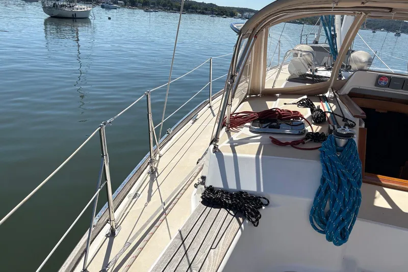 Slide: The Image of 2005 Tartan 4100 sailboat deck with ropes, docked on calm water. - 26