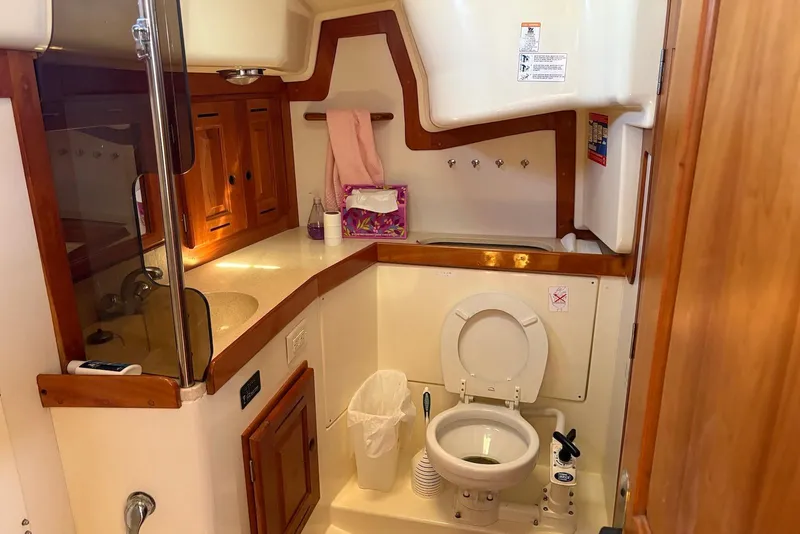 Slide: The Image of Bathroom interior of a 2005 Tartan 4100 yacht, featuring wooden cabinetry and a compact toilet. - 3