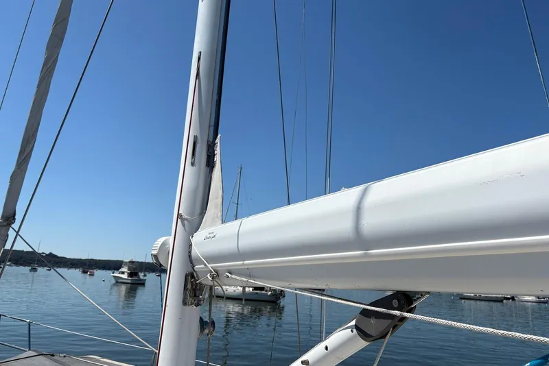 Slide: The Image of Sailboat mast and boom of 2005 Tartan 4100 on calm water under clear blue sky. - 30