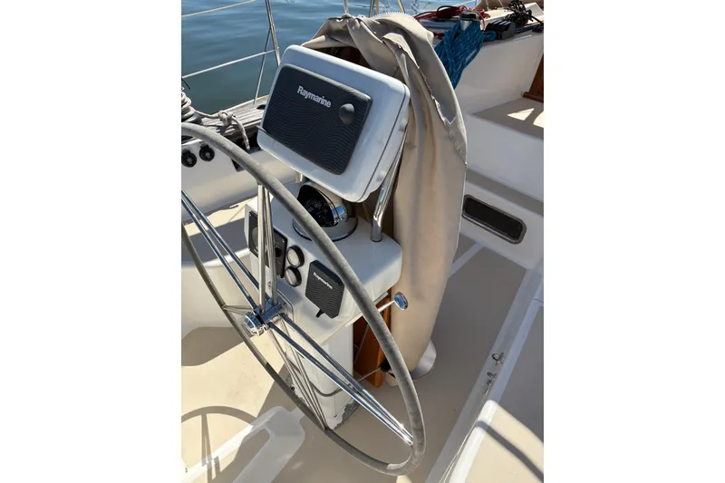 Slide: The Image of Steering wheel and controls of a 2005 Tartan 4100 sailboat, featuring Raymarine equipment. - 39