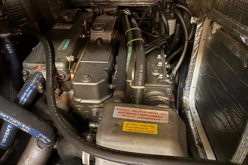 Slide: The Image of Engine compartment of a 2005 Tartan 4100, featuring hoses and mechanical components. - 54