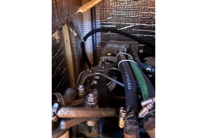Slide: The Image of Engine compartment of a 2005 Tartan 4100 sailboat, showing hoses and mechanical components. - 58