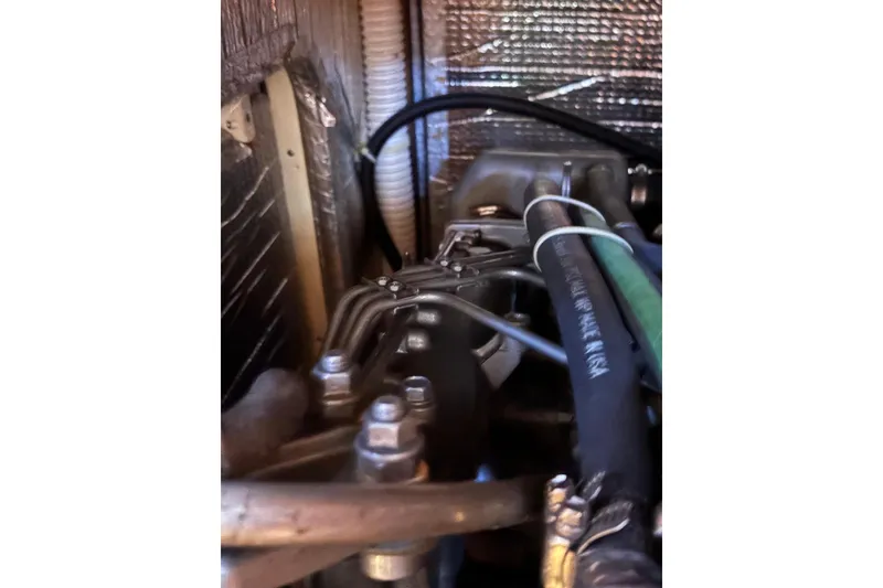 Slide: The Image of Engine compartment of a 2005 Tartan 4100 sailboat, showing hoses and metal components. - 61