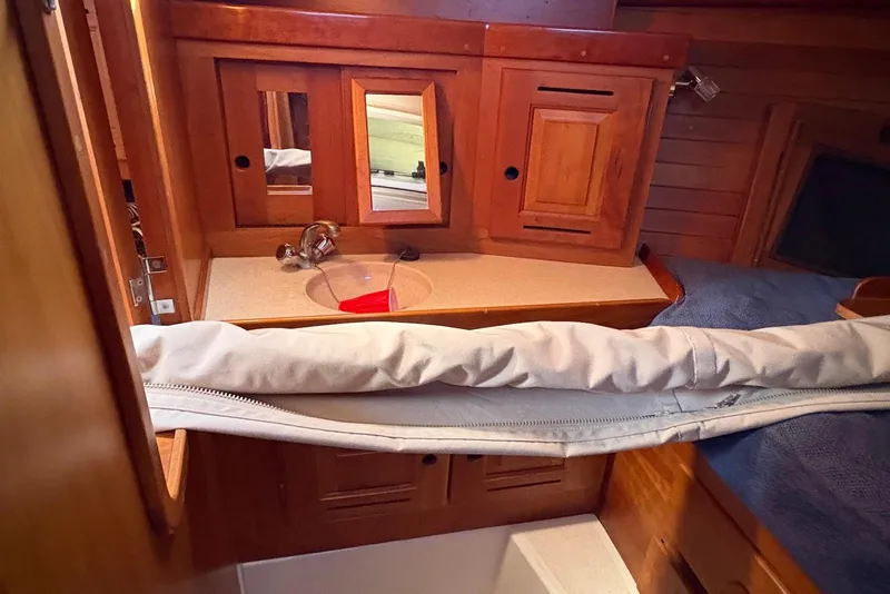 Slide: The Image of Interior of 2005 Tartan 4100 sailboat with wooden cabinetry and compact sink area. - 9
