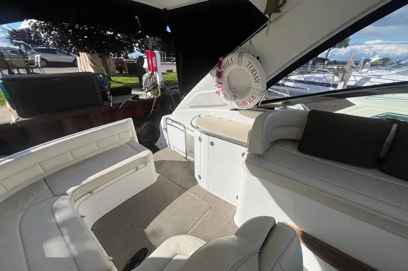 Slide: The Image of 2009 Cobalt 373 boat interior with white seating and life preserver, docked at marina. - 14