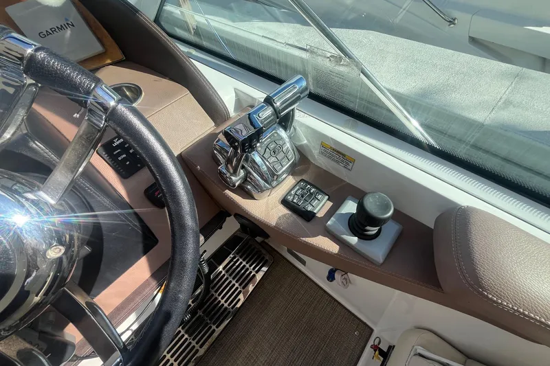 Slide: The Image of 2009 Cobalt 373 boat helm with steering wheel, controls, and Garmin device. - 21