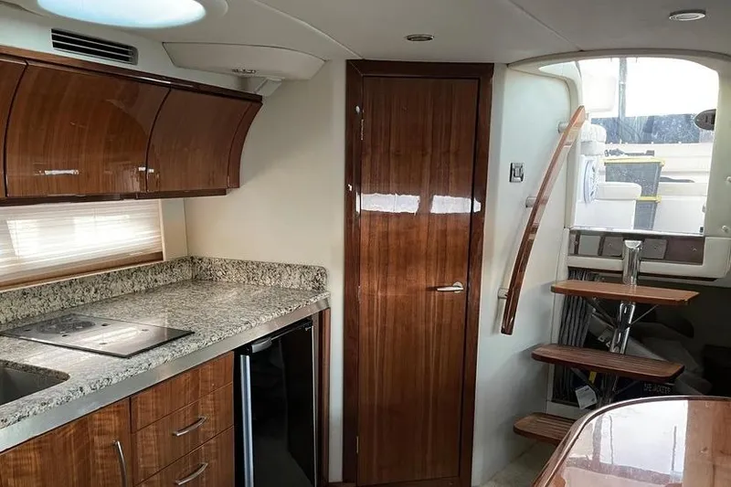 Slide: The Image of 2009 Cobalt 373 yacht interior with wooden cabinetry, granite countertops, and compact staircase. - 26