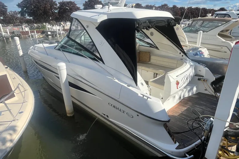 Slide: The Image of 2009 Cobalt 373 boat docked at marina, featuring sleek design and spacious seating area. - 3