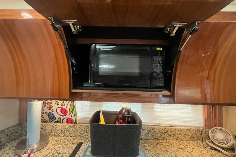 Slide: The Image of 2009 Cobalt 373 kitchen with microwave, wooden cabinets, and granite countertop. - 37