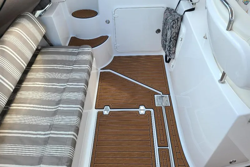 Slide: The Image of 2009 Regal Commodore 3760 IB boat interior with striped seating and wood-patterned flooring. - 10