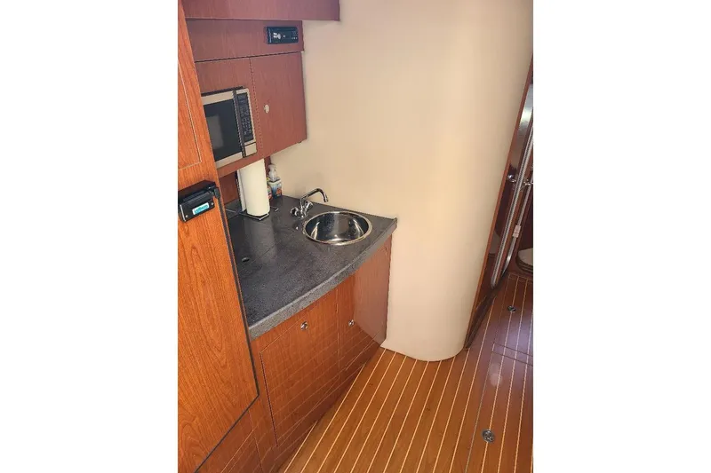 Slide: The Image of 2009 Regal Commodore 3760 IB yacht interior with kitchenette, sink, and microwave. - 13