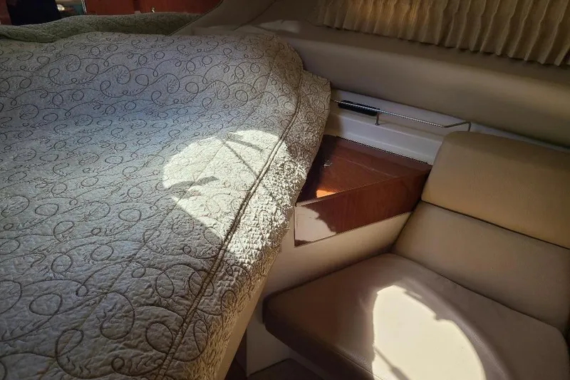 Slide: The Image of Interior of 2009 Regal Commodore 3760 IB with quilted bedding and cushioned seating. - 18