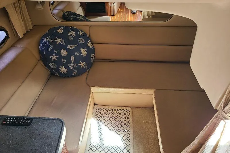 Slide: The Image of 2009 Regal Commodore 3760 IB cabin interior with beige seating and nautical-themed cushion. - 19