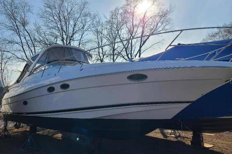 Slide: The Image of 2009 Regal Commodore 3760 IB boat on stands, sunlit with bare trees in background. - 21