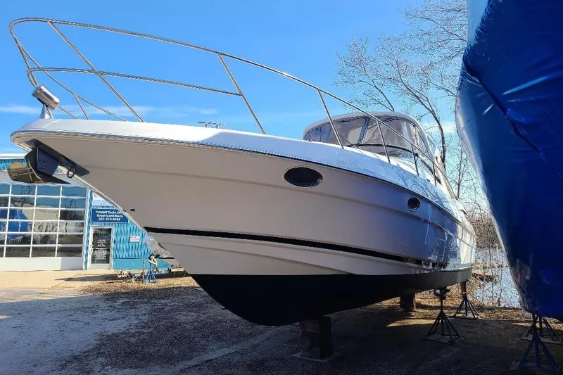 Slide: The Image of 2009 Regal Commodore 3760 IB boat on stands, outside a blue building. - 22