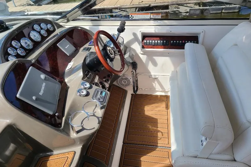 Slide: The Image of 2009 Regal Commodore 3760 IB boat cockpit with steering wheel, gauges, and white seating. - 6