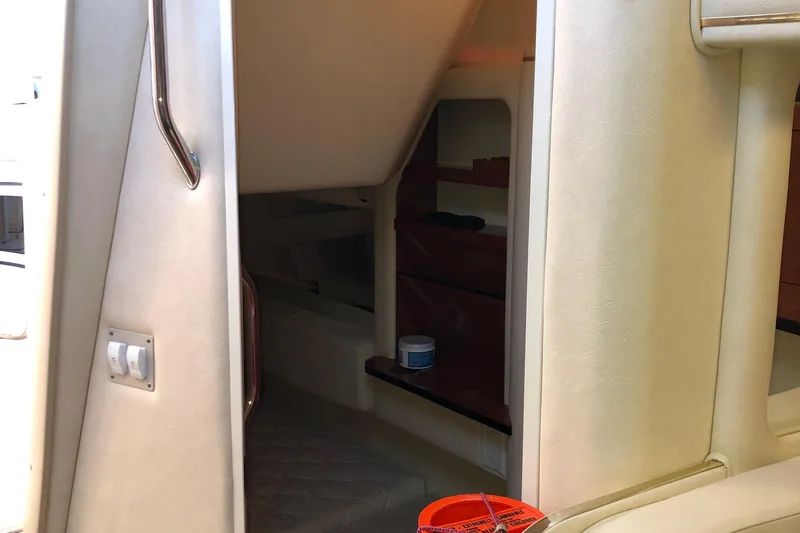 Slide: The Image of 2001 Sea Ray 290 Sundancer cabin interior with beige walls and shelving. - 17