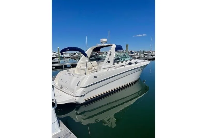 Slide: The Image of 2001 Sea Ray 290 Sundancer boat docked in marina under clear blue sky. - 2