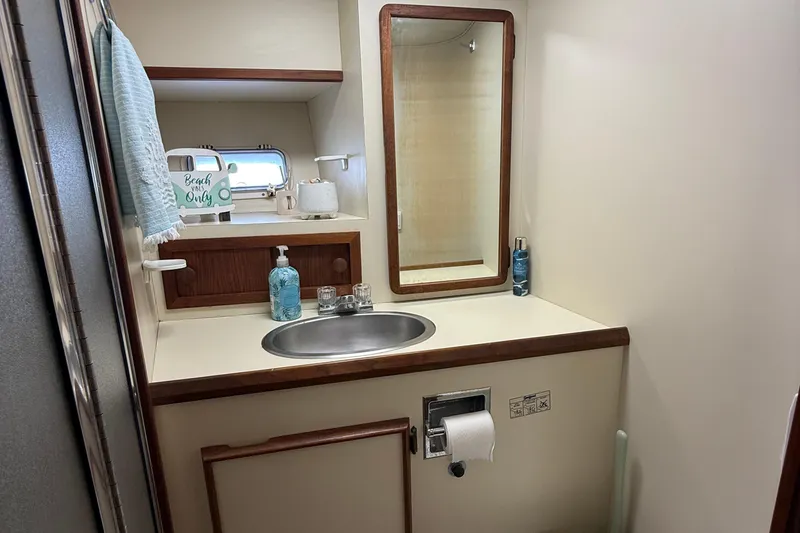Slide: The Image of 1987 Chris-Craft 392 Commander bathroom with sink, mirror, and nautical decor. - 12