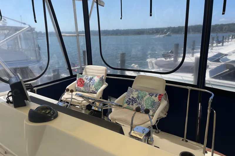 Slide: The Image of 1987 Chris-Craft 392 Commander helm with scenic marina view, featuring comfortable seating. - 15