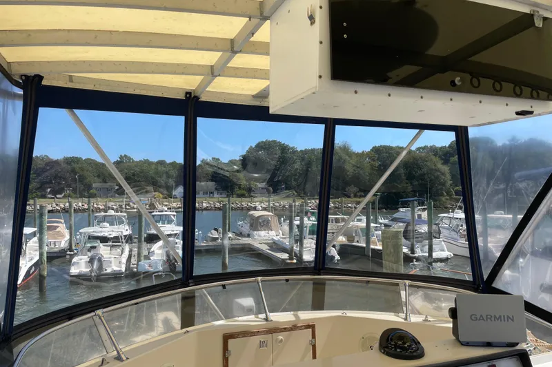 Slide: The Image of 1987 Chris-Craft 392 Commander cockpit view overlooking marina with multiple boats docked. - 17